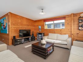 A living room with a television and seating at Whangapoua