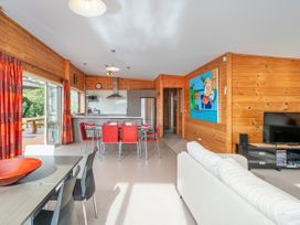 A living room with a dining area and kitchen at Whangapoua
