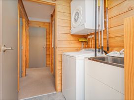 A laundry room with a washing machine and a dryer at Whangapoua