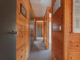 A hallway with wooden walls and doors at Whangapoua