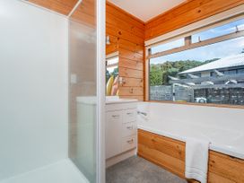 A bathroom with a shower, bathtub, and sink at Whangapoua