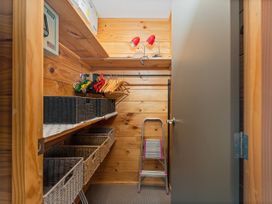 A closet with shelves, hangers, and storage baskets at Whangapoua