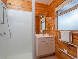 A bathroom with a shower and sink at Whangapoua