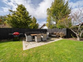 A garden area with a dining table and grill at Te Anau - Holiday Home