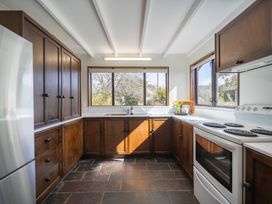 A kitchen with cabinets and a window at Te Anau - Holiday Home