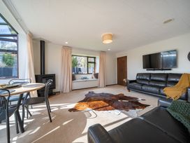 A living room with a fireplace and a sofa at Te Anau - Holiday Home