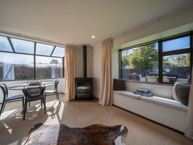 A sunroom with a table and chairs at Te Anau - Holiday Home