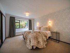 A bedroom with a bed and window at Te Anau - Holiday Home