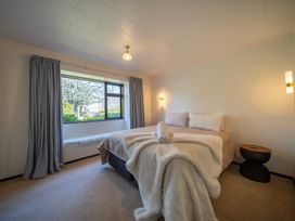 A bedroom with a bed and window at Te Anau - Holiday Home