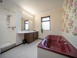 A bathroom with a bathtub and vanity at Te Anau - Holiday Home