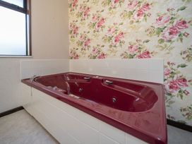 A jacuzzi with a floral patterned wall at Te Anau - Holiday Home