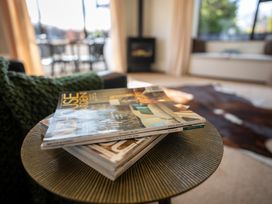 A living room with magazines on a coffee table at Te Anau - Holiday Home