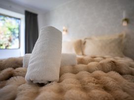 A bed with towels and decorative pillows at Te Anau - Holiday Home