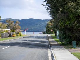 A road with traffic signs and mountains in the background at Te Anau - Holiday Home