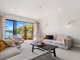 A living room with a sofa and coffee table with a view of the lake at Rotorua