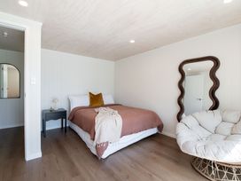 A bedroom with a bed and armchair at Rotorua