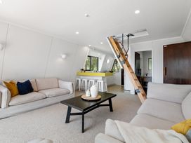 A living room with a staircase and kitchen area at Rotorua