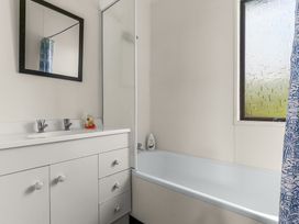 A bathroom with a sink, mirror, shower, and bath at Snells Beach