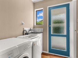 A laundry room with a washing machine and a sink at Snells Beach