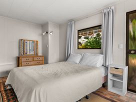 A bedroom with a bed and dressing table at Snells Beach