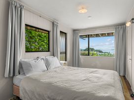 A bedroom with a bed and windows at Snells Beach in 
