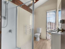 A bathroom with a shower, toilet, and sink at Snells Beach