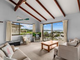 A living room with a view and furniture at Snells Beach