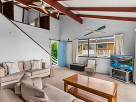 A living room with a sofa and television at Snells Beach