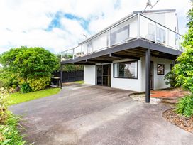 A house with a balcony and garden at Snells Beach