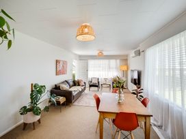 A living room with a sofa and dining table at Havelock North Holiday Home
