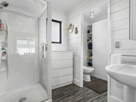 A bathroom with a shower, toilet, and vanity at Whitianga Holiday Home in Whitianga