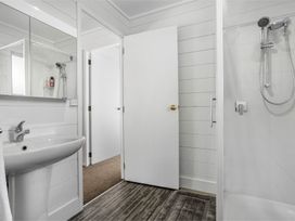 A bathroom with a sink and shower at Whitianga Holiday Home in Whitianga