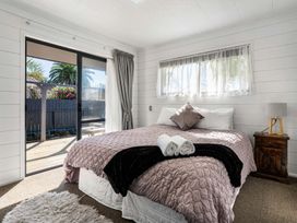 A bedroom with a bed and window at Whitianga Holiday Home in Whitianga