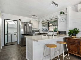 A kitchen with a refrigerator, stove, and sink at Whitianga Holiday Home in Whitianga