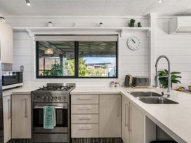 A kitchen with a stove and sink at Whitianga Holiday Home in Whitianga