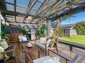 An outdoor patio area with seating and grill at Whitianga Holiday Home in Whitianga