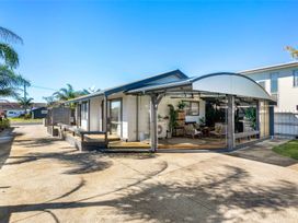 A house with a porch and furniture at Whitianga Holiday Home in Whitianga