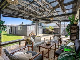 An outdoor patio with furniture and plants at Whitianga Holiday Home in Whitianga