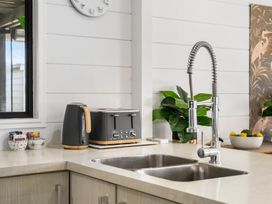 A kitchen with a sink, kettle, and toaster at Whitianga Holiday Home in Whitianga
