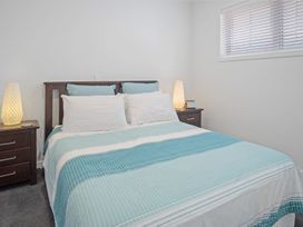 A bedroom with a bed and bedside tables at Tindall's Beach Whangaparaoa Peninsula
