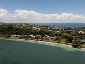 An aerial view of houses along a beach at Tindall's Beach in Whangaparaoa Peninsula