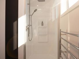 A shower with showerhead and wall shelves at Tindall's Beach Whangaparaoa Peninsula