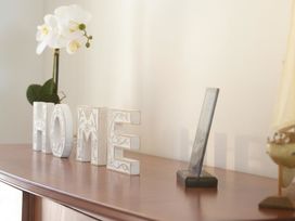 A decorative display with home letters and a flower in a living room at Tindall's Beach Whangaparaoa Peninsula