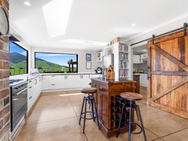 A kitchen with a countertop, stools, and views of mountains at The Old Barn in Manchester