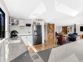 A kitchen with refrigerator, sink, and shelves at 