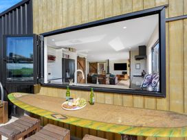 An outdoor dining area with a bar table and bottles at a property in 