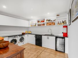 A laundry room with appliances and shelves at The Old Barn in Manchester