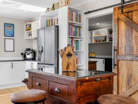 A kitchen with a wooden table and bookshelves at The Old Barn in Manchester