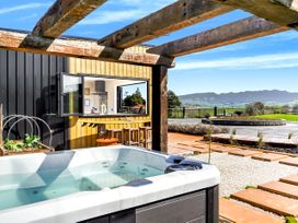 An outdoor area with a hot tub and seating at a property