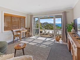 A living room with a table and chairs at Red Beach Retreat - Whangaparaoa Peninsula